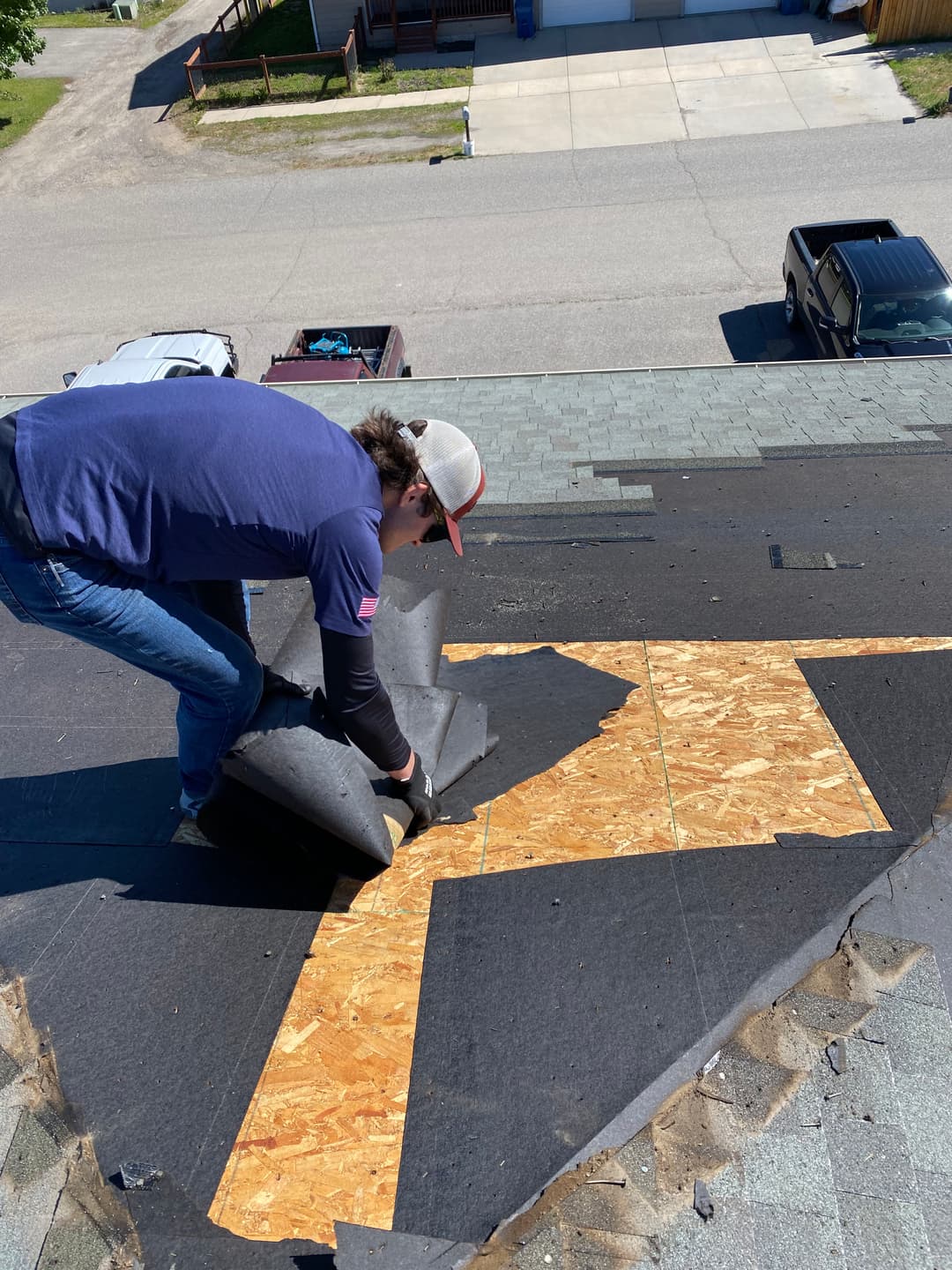 Roofing contractor installing underlayment on a residential roof, ensuring proper waterproofing.