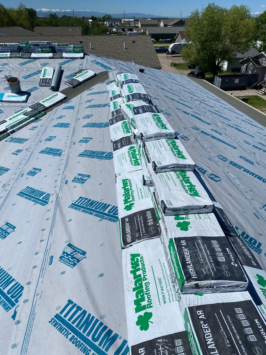 Roofing installation with Titanium underlayment and stacked shingles on a residential home.
