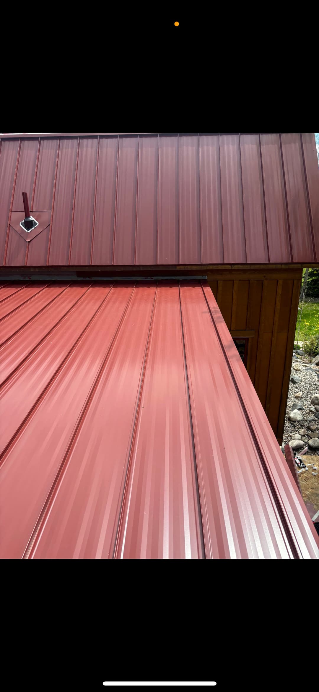 Metal roofing in red tones showing overlapping panels and side detail. Suitable for residential use.